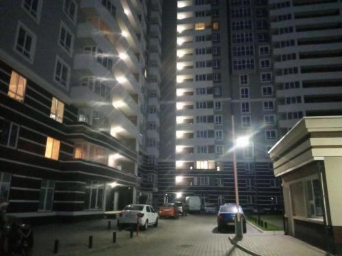 a city street at night with cars parked in front of tall buildings at Апартаменти Люкс 4 in Khmelnytskyi