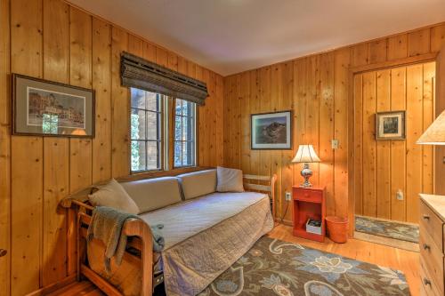 een slaapkamer met een bed in een kamer met houten wanden bij 5-Acre Allenspark Cabin with Rocky Mntn Views and Pond in Allenspark