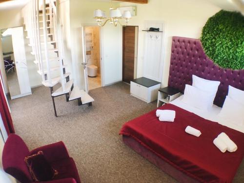 a bedroom with a large red bed and a staircase at ART Boutique Chalet in Yanoshi