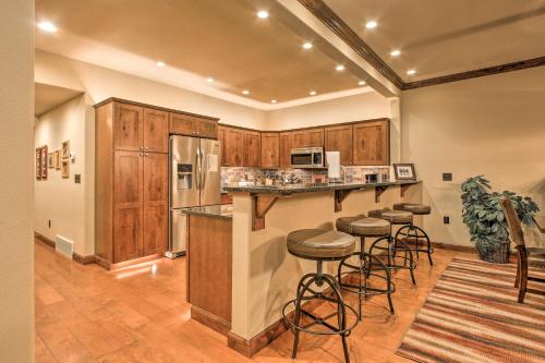 a kitchen with wooden cabinets and bar stools at Red Lodge Townhome with Private Hot Tub and Mtn Views! in Red Lodge