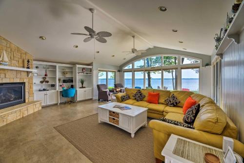 a living room with a yellow couch and a fireplace at Bayfront Blounts Creek Home Private Beach and Dock! in Whichard Beach