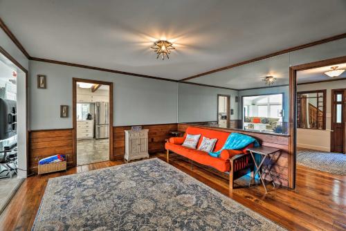 a living room with an orange couch and a mirror at Bayfront Blounts Creek Home Private Beach and Dock! in Whichard Beach