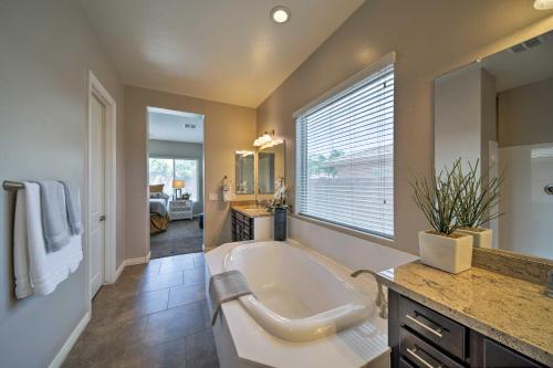 a large bathroom with a large tub and a large window at Hot Tub and Putting Green Home in Surprise in Surprise