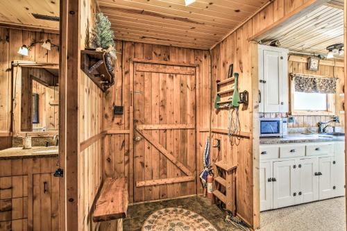 a kitchen with a wooden wall with a door at Baldwin Cabin with Private Beach on Little Lake! in Baldwin