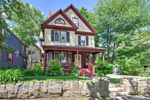 a house with a stone fence in front of it at Central Bar Harbor Home, Walk to the Shore and Town! in Bar Harbor