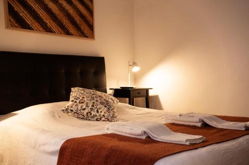 a bed with a blanket and pillows on top of it at Burgos Guest House in Évora