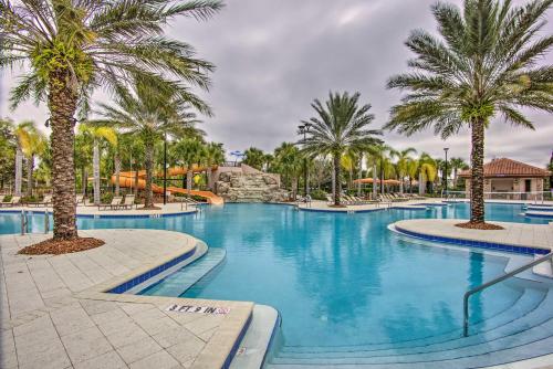 a large swimming pool with palm trees and a slide at Less Than 10 Mi to Disney Prime Resort Villa with Pool in Davenport
