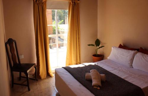 1 dormitorio con 1 cama, 1 silla y 1 ventana en Estación Aeropuerto Ezeiza en Lomas de Zamora