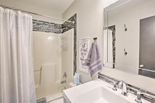 a white bathroom with a sink and a mirror at Modern Excelsior Springs Home with Deck and 3 Acres! in Excelsior Springs