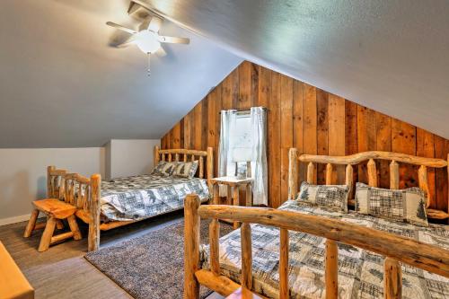 sypialnia z 2 łóżkami i drewnianymi ścianami w obiekcie Logan Vacation Rental with Deck, Hot Tub and Pond! w mieście Logan