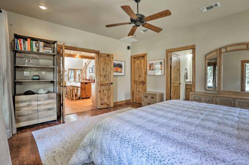 een slaapkamer met een bed en een plafondventilator bij Riverfront Blanco Home with Shaded Porch and Hot Tub in Blanco