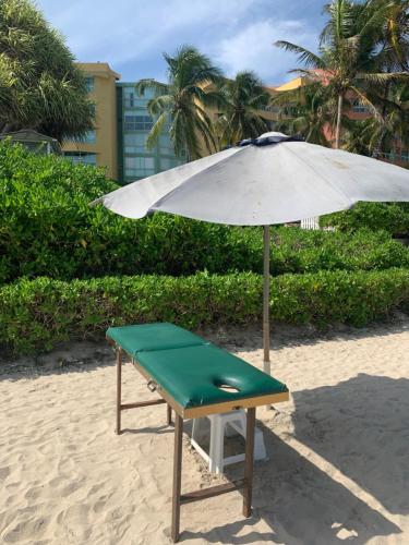 a chair and an umbrella on the beach at Cimarron Suites Playa Parguito in Aricagua