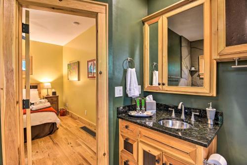 a bathroom with a sink and a mirror and a bed at Romantic Asheville Area Cabin with Deck and Hot Tub! in Leicester