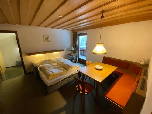 a small bedroom with a bed and a table at Chalet Elfie in Sankt Anton am Arlberg