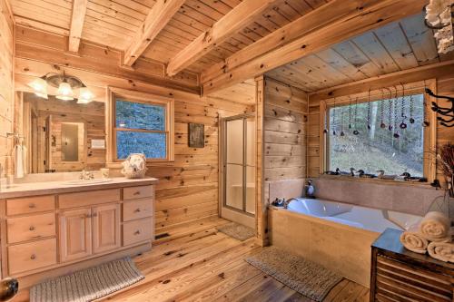 a log cabin bathroom with a tub and a sink at Riverside Ellijay Cabin with Hot Tub and Game Room in Ellijay
