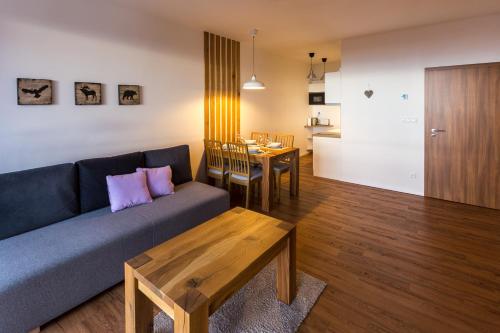 una sala de estar con un sofá y una mesa en Apartment Chamonix PRIMO, en Starý Smokovec