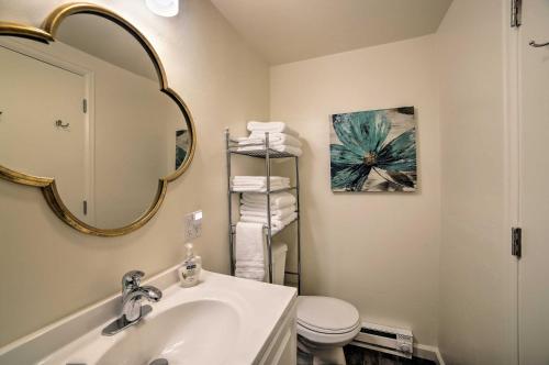 a bathroom with a sink and a mirror and a toilet at Cozy Grand Junction Bungalow by Trails and Wineries! in Grand Junction
