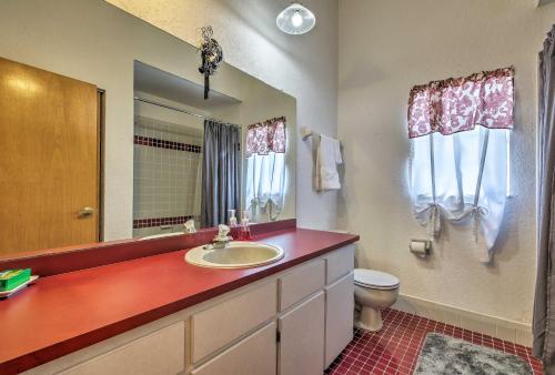 a bathroom with a sink and a toilet and a mirror at 1 Mi to Weeki Wachee Home with Pool in Spring Hill in Spring Hill