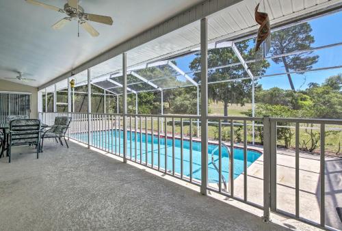 a balcony with a pool and a ceiling fan at 1 Mi to Weeki Wachee Home with Pool in Spring Hill in Spring Hill