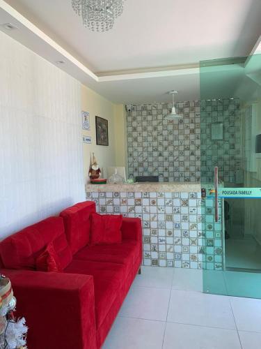 a living room with a red couch and a kitchen at Pousada Familly -Praia de Tambaú -PB in João Pessoa
