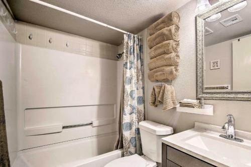 een badkamer met een wastafel, een toilet en een spiegel bij Beach Haven with Shared Amenities - Steps to Beach! in South Padre Island
