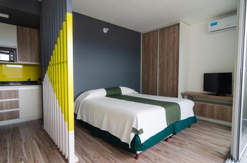 1 dormitorio con 1 cama con cabecero amarillo y verde en Donna Alda DFC en Salta