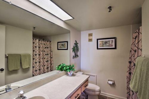 La salle de bains est pourvue d'un lavabo, de toilettes et d'un miroir. dans l'établissement Coastal Condo with Balcony Walk to Madeira Beach!, à St. Pete Beach