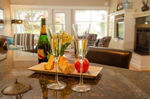 a table with two wine glasses and a bottle of champagne at Crown Mansion Boutique Hotel & Villas in Qualicum Beach