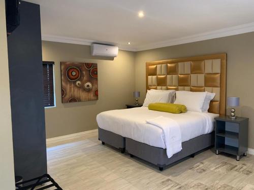 a bedroom with a large bed and a painting on the wall at La Fiato Luxury Lodge in Dalmada AH