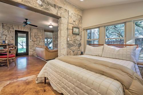 a bedroom with a large bed and a stone wall at Blanco Riverfront Historic Home, 3 Mi to Downtown! in Blanco