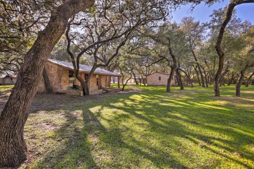 a house in the middle of a field with trees at Blanco Riverfront Historic Home, 3 Mi to Downtown! in Blanco
