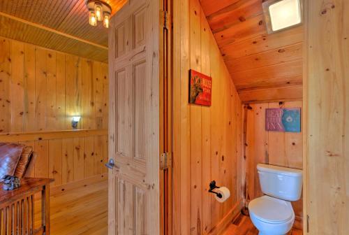 a bathroom with a toilet in a wooden cabin at Beautiful Bryson City Home with Hot Tub and Mtn Views! in Bryson City