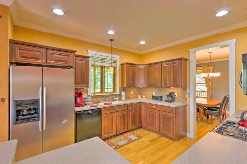 a kitchen with wooden cabinets and a stainless steel refrigerator at Beautiful Bryson City Home with Hot Tub and Mtn Views! in Bryson City
