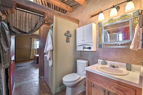 a bathroom with a toilet and a sink and a mirror at El Prado Adobe Home Courtyard with Mountain Views! in El Prado