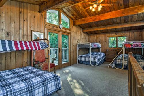 a bedroom with three bunk beds in a cabin at Lakefront Montague Cottage with Deck and Beach! in Rothbury