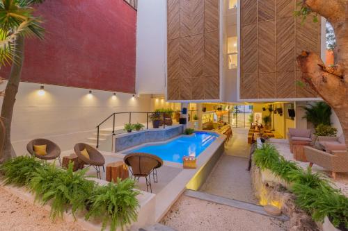 a house with a pool and tables and chairs at oOstel Smart Hostel - Tulum Pueblo in Tulum