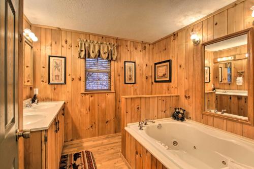 bagno con pareti in legno, vasca e lavandino di Private Gatlinburg Cabin Pet Friendly with Hot Tub! a Gatlinburg