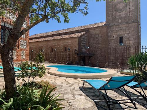 un patio con piscina y sillas y un edificio en Doña Garosa en Hita