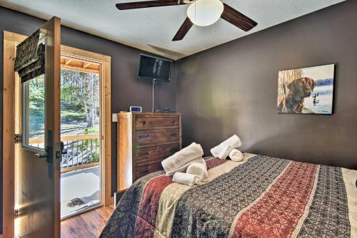 - une chambre avec un lit, un ventilateur de plafond et une fenêtre dans l'établissement Elk Path Cabin with Hot Tub and Deck Near Asheville!, à Weaverville