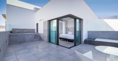 1 dormitorio con cama, mesa y espejo en Dormos Hotel, en Cádiz