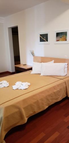 een slaapkamer met een bed met twee handdoeken erop bij Ilha da Galé Tourist Hotel Fazenda de Bombas in Bombinhas
