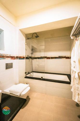 a bathroom with a shower with a toilet and a tub at Hotel Country Villa in Nagarkot