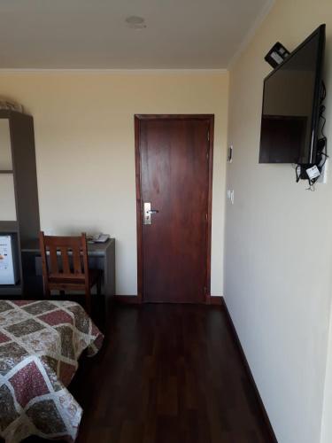 Un dormitorio con una cama y una puerta de madera. en Hotel Dos Mares, en Balneario Mar Chiquita