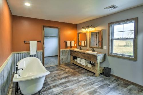 a bathroom with a tub and a sink and a mirror at Lakefront Wisconsin Dells Home with Game Room in Wisconsin Dells