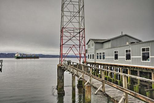 a building on the water next to a dock at Sleek Riverfront Condo on Pier in Downtown Astoria in Astoria, Oregon