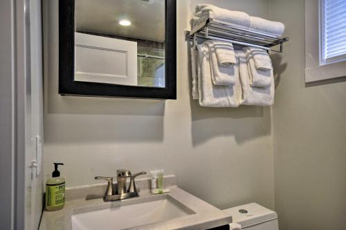 a bathroom with a sink and a mirror and towels at Sleek Riverfront Condo on Pier in Downtown Astoria in Astoria, Oregon