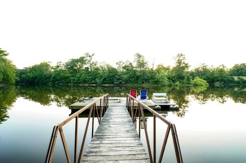 a dock with boats on a body of water at Remote Cabin on 30 Acres with Dock and Private Lake! in Macks Creek