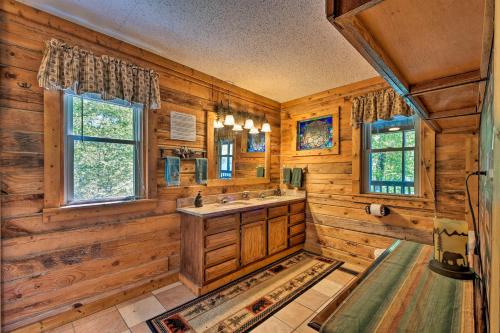 查塔努加的住宿－Tenn River Cabin with Hot Tub - 10 Mi to Chattanooga!，一间带木墙和水槽的浴室以及两个窗户