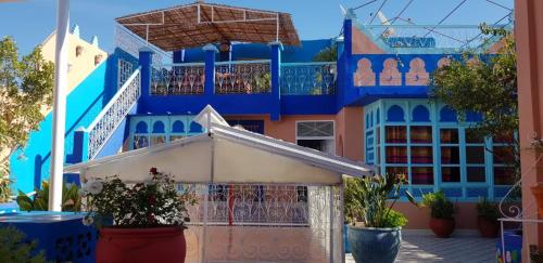 a blue building with balconies and plants in front of it at Riad Konouz in Marrakech