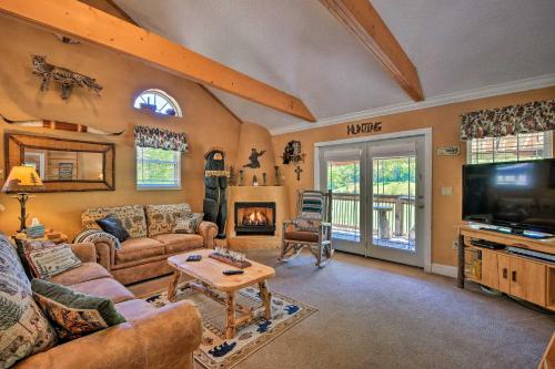a living room with a couch and a tv at Cozy Cabin on Tenn River - 10 Mi to Chattanooga! in Chattanooga